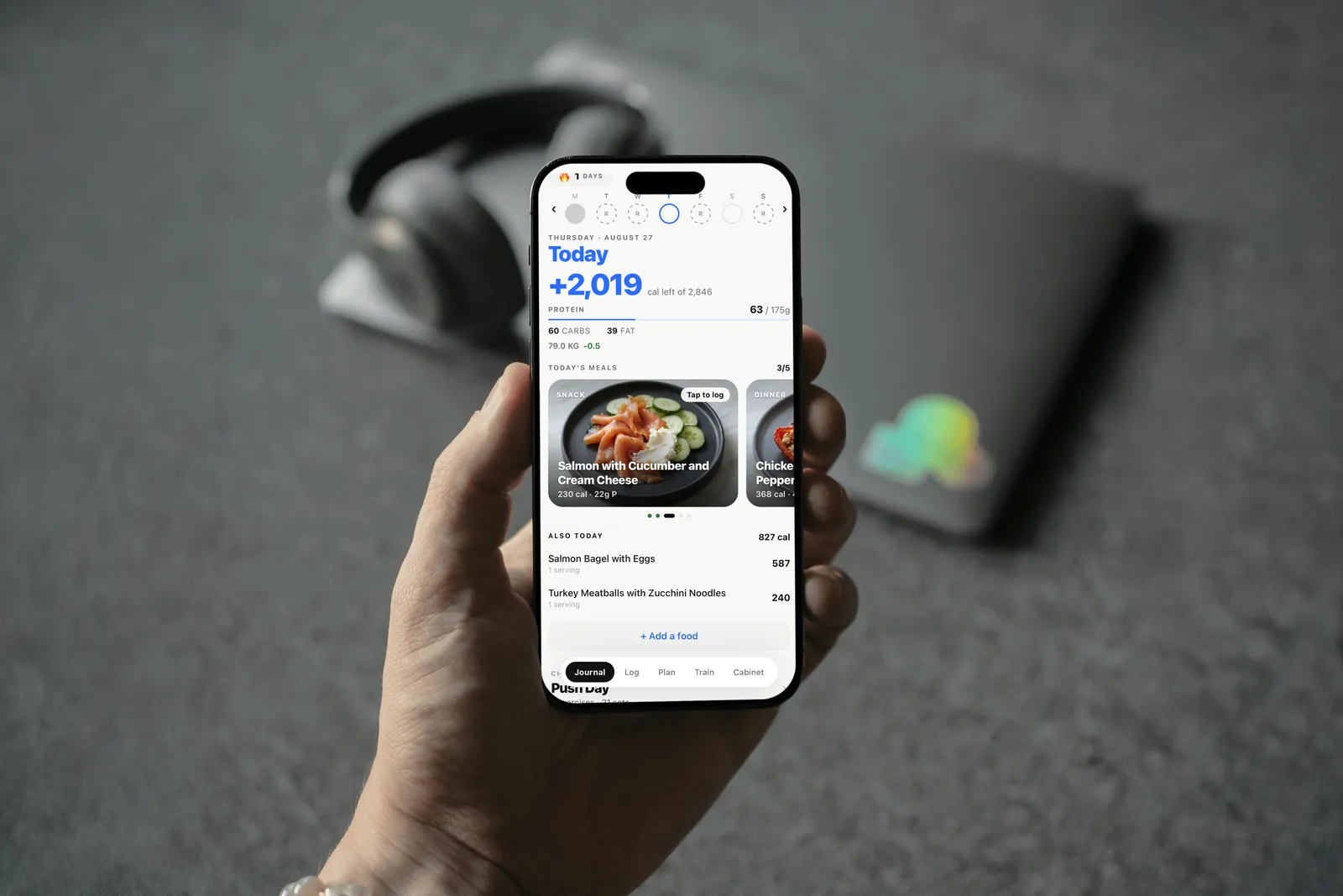 Fitevolve's food log open on an iPhone, held in a hand